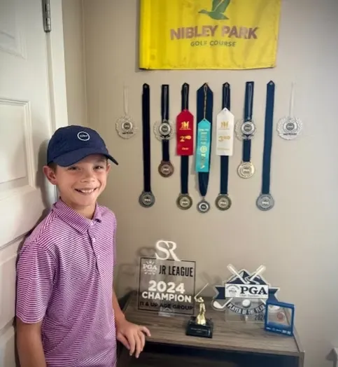 Cannon Murdock with junior golf trophies and medals